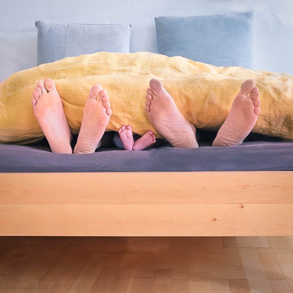 adults child feet in bed