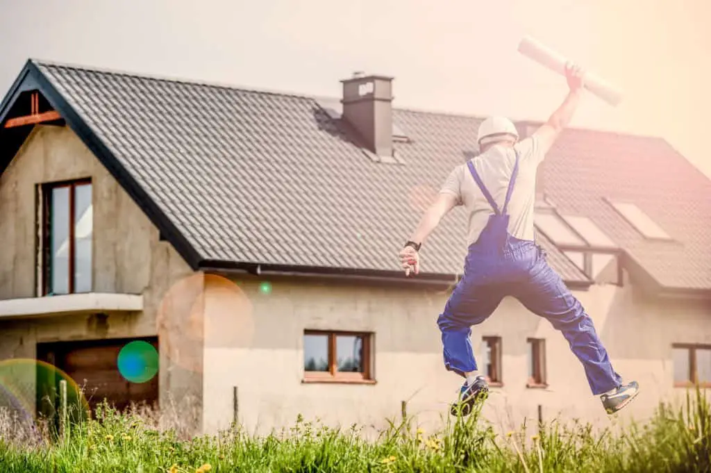 architect jumping in front of house